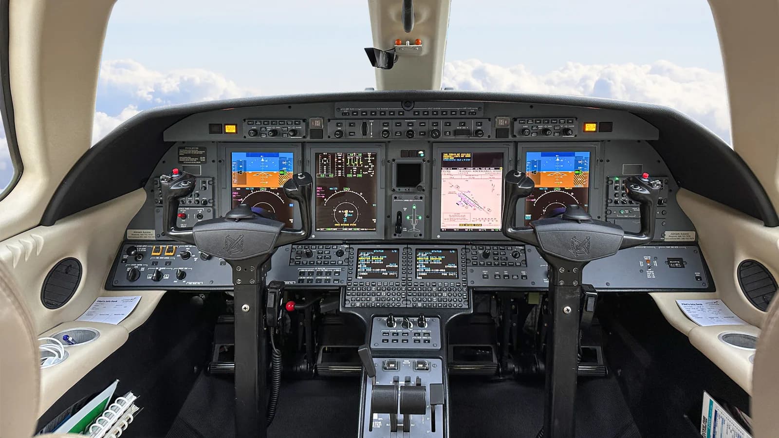 The modern glass cockpit of a Citation CJ4 business jet, featuring multiple display screens and control yokes.