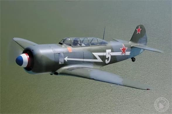 A Lavochkin La-9 in flight with a gray and green paint scheme and a red star on the tail.
