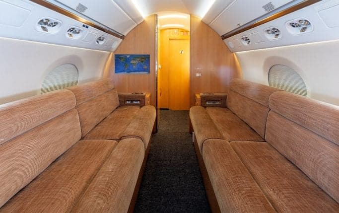 Aircraft cabin interior with a table and cabinets.
