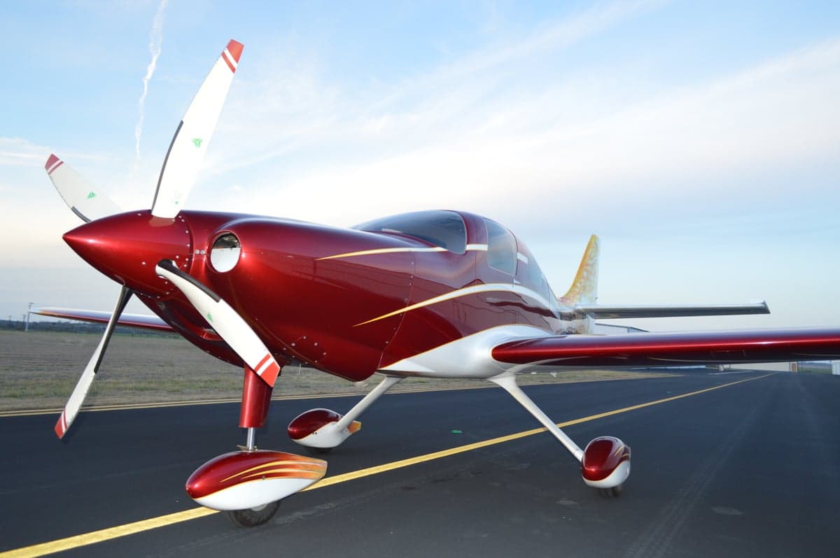 A red and white aircraft with a flame design on the tail sits on the tarmac.