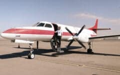 An aerial view of a Beechcraft Baron with a blue and white paint scheme.