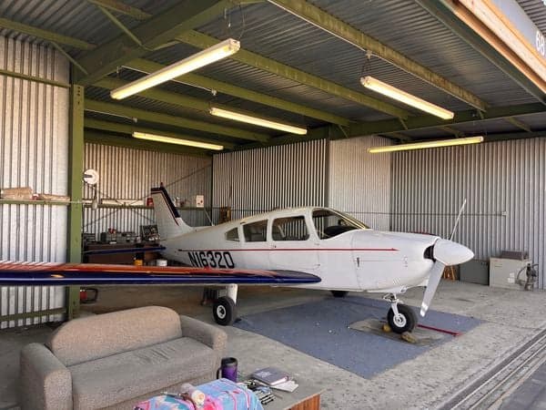 Piper Cherokee 16320 aircraft parked inside a hangar.