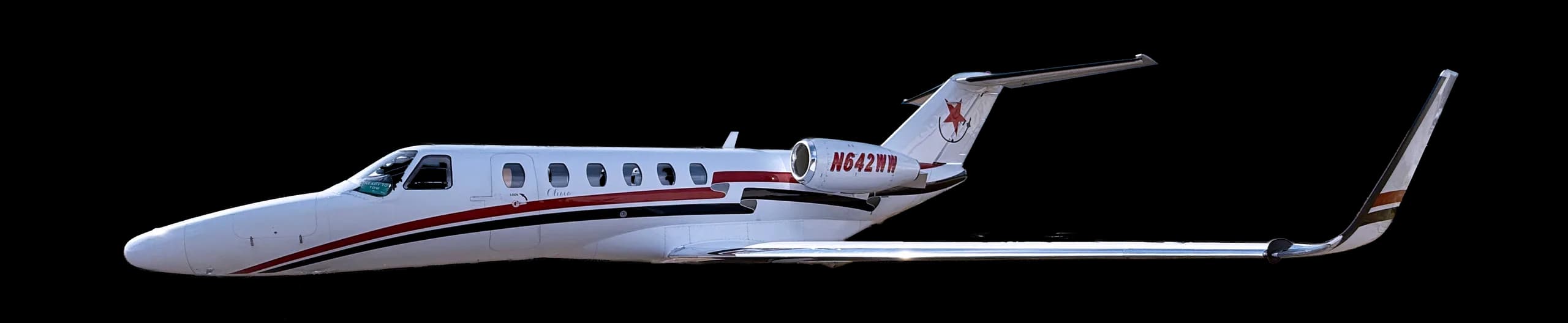 Side view of a white and red jet with registration N642WM against a black background.