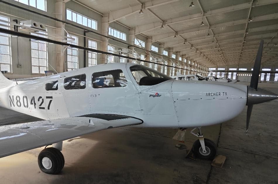 Piper Archer TX aircraft, registration N80427, parked inside a hangar.