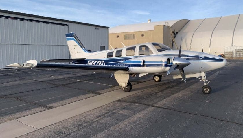 Beechcraft Baron N18280 parked on the tarmac in front of a hangar.