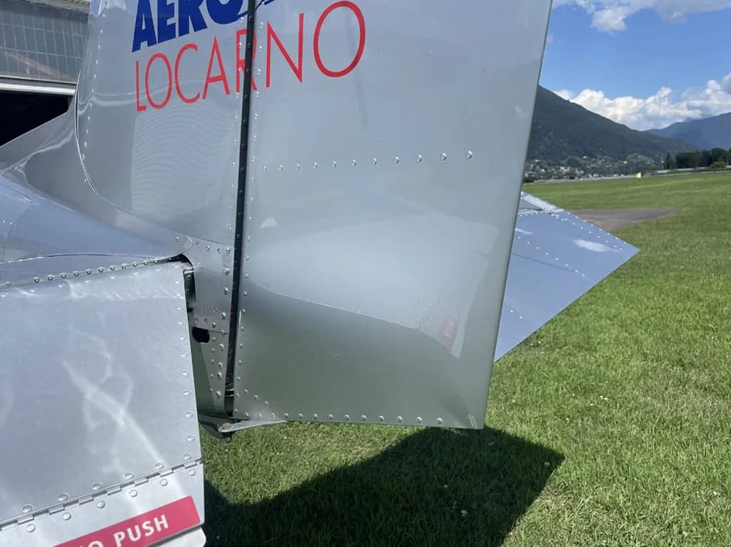 A detailed close-up of the silver tail section of the Sonaca 200 aircraft, showing rivets and "AERO LOCARNO" text.