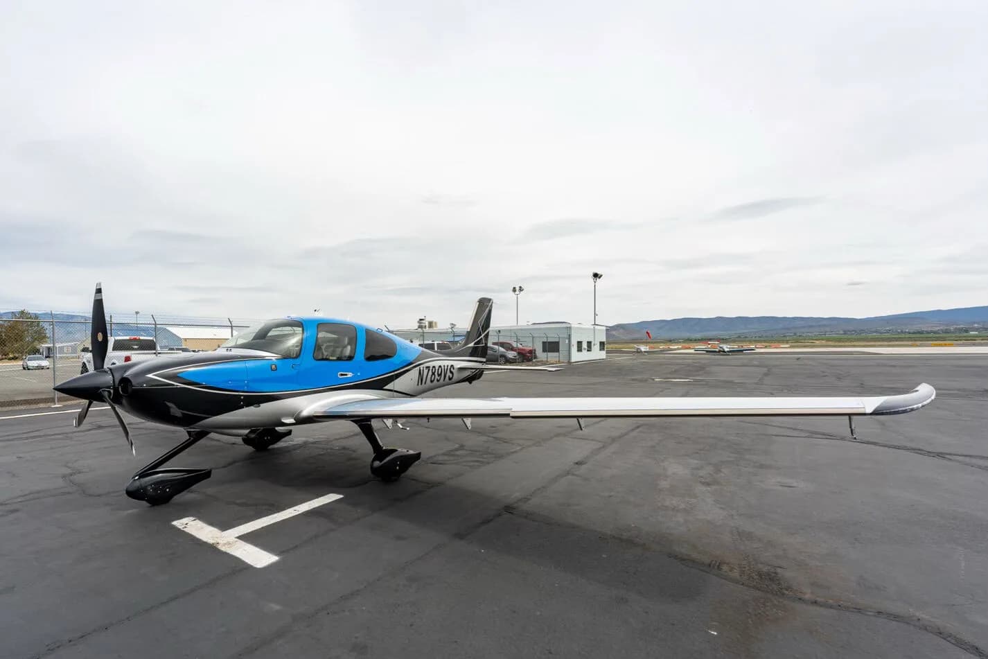 Three-quarter front view of a black, blue, and silver single-engine aircraft with registration N789VS on an airfield.