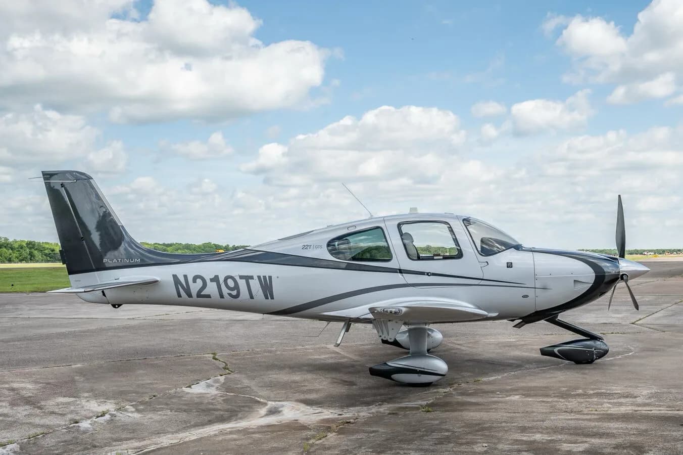 A side profile of the Cirrus SR22T GTS Platinum aircraft N219TW with its silver and black paint scheme.