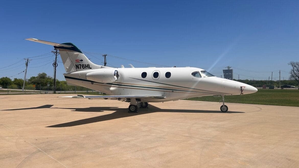 Side view of the N76HL Premier I aircraft on the tarmac.