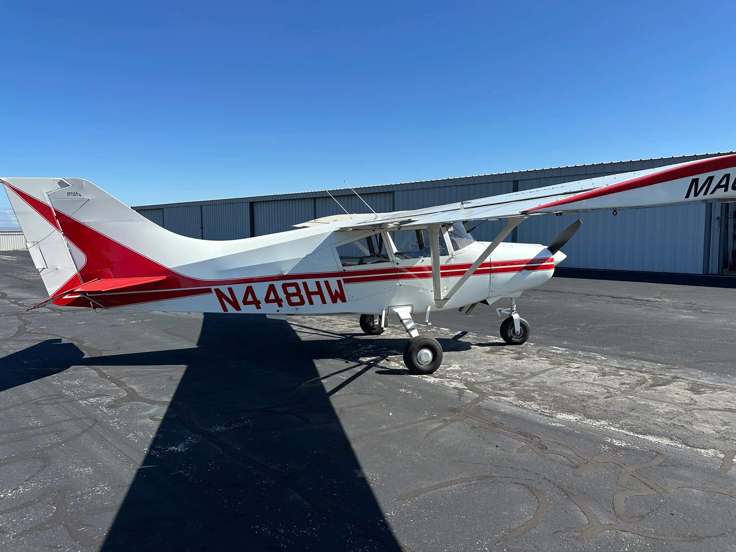 A Maute aircraft with red and white paint scheme is parked on the tarmac.