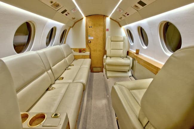 The interior of the aircraft features leather seats and wood trim.