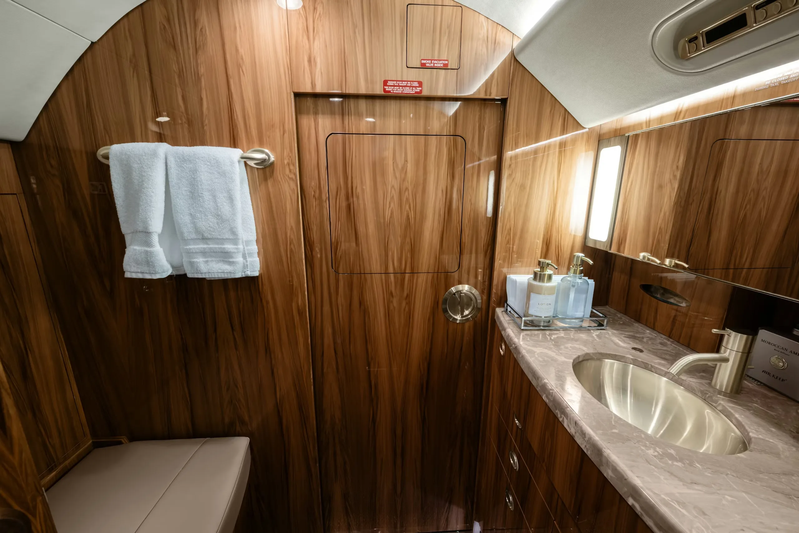 Interior view of the aircraft lavatory with a sink and mirror.