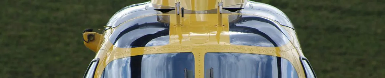 Close-up of the cockpit of a yellow helicopter.