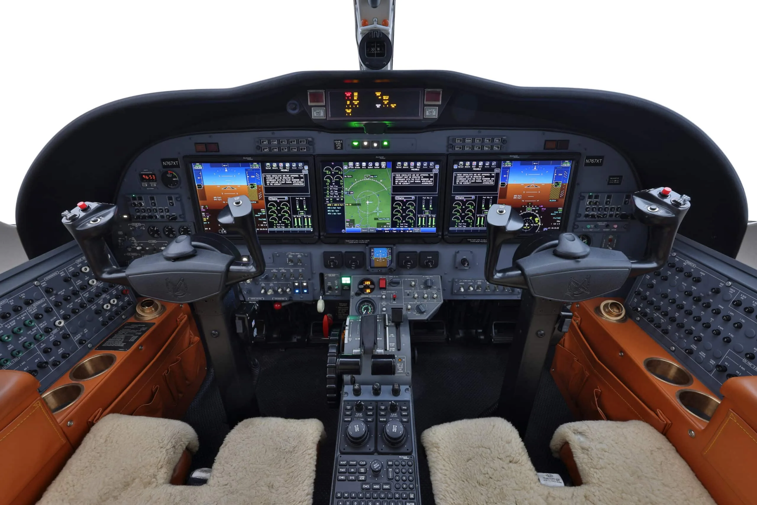 Cockpit of a private jet with multiple digital displays and flight controls, showing registration N767XT.