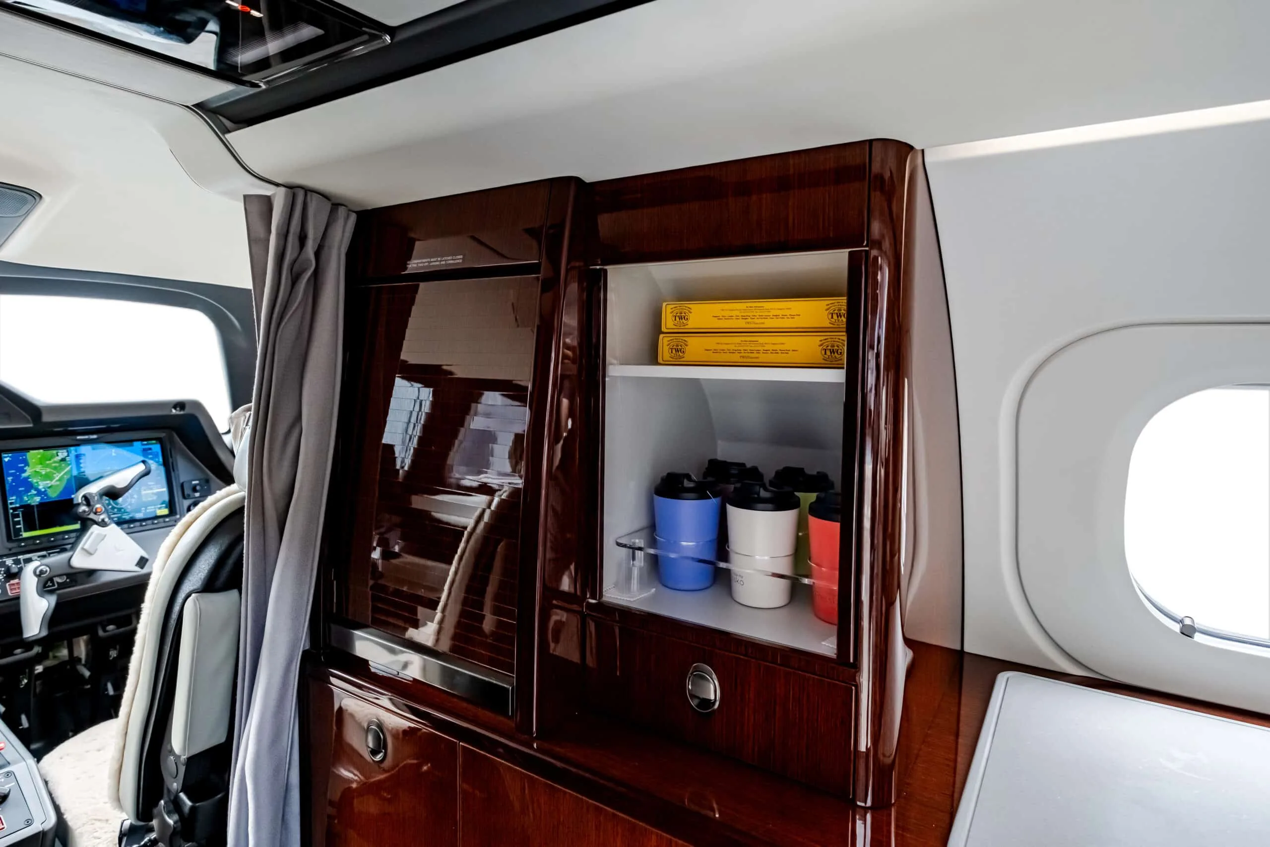 View of the aircraft interior with cabinets and cockpit in the background.