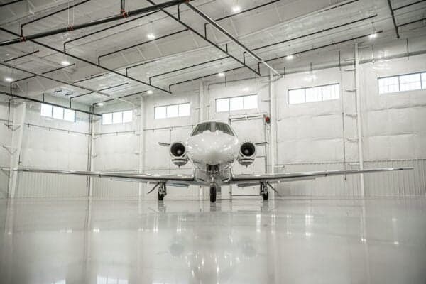 A Citation jet, N338HR, is parked in a hangar, facing the camera.