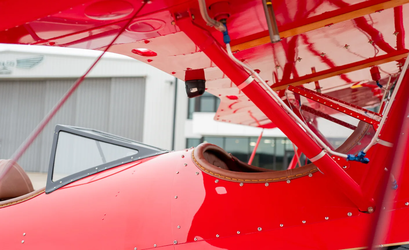 Close up of the cockpit area of a red biplane.