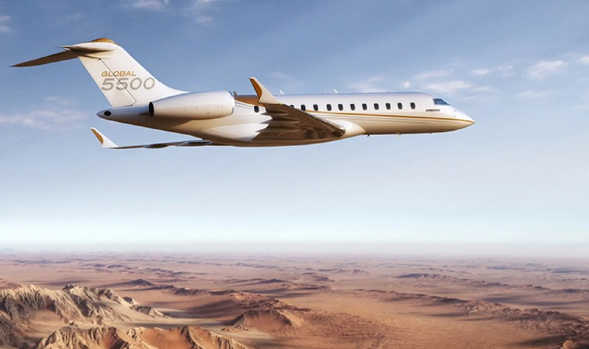 A Bombardier Global 5500 flying over a desert landscape.