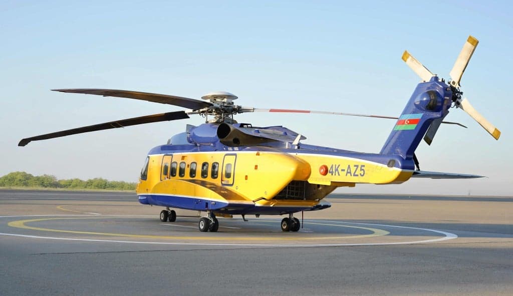 A blue and yellow helicopter on the ground.