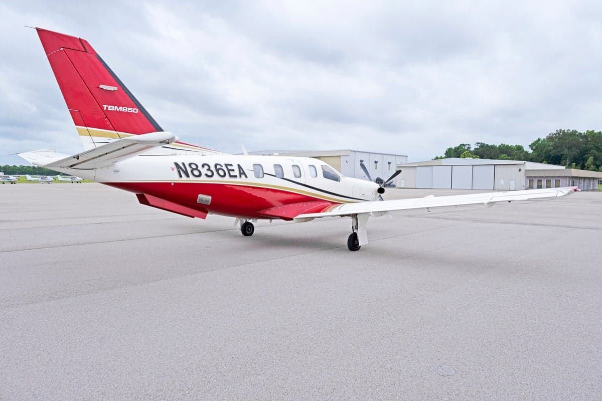 Side view of the TBM 850 aircraft N836EA on the tarmac.