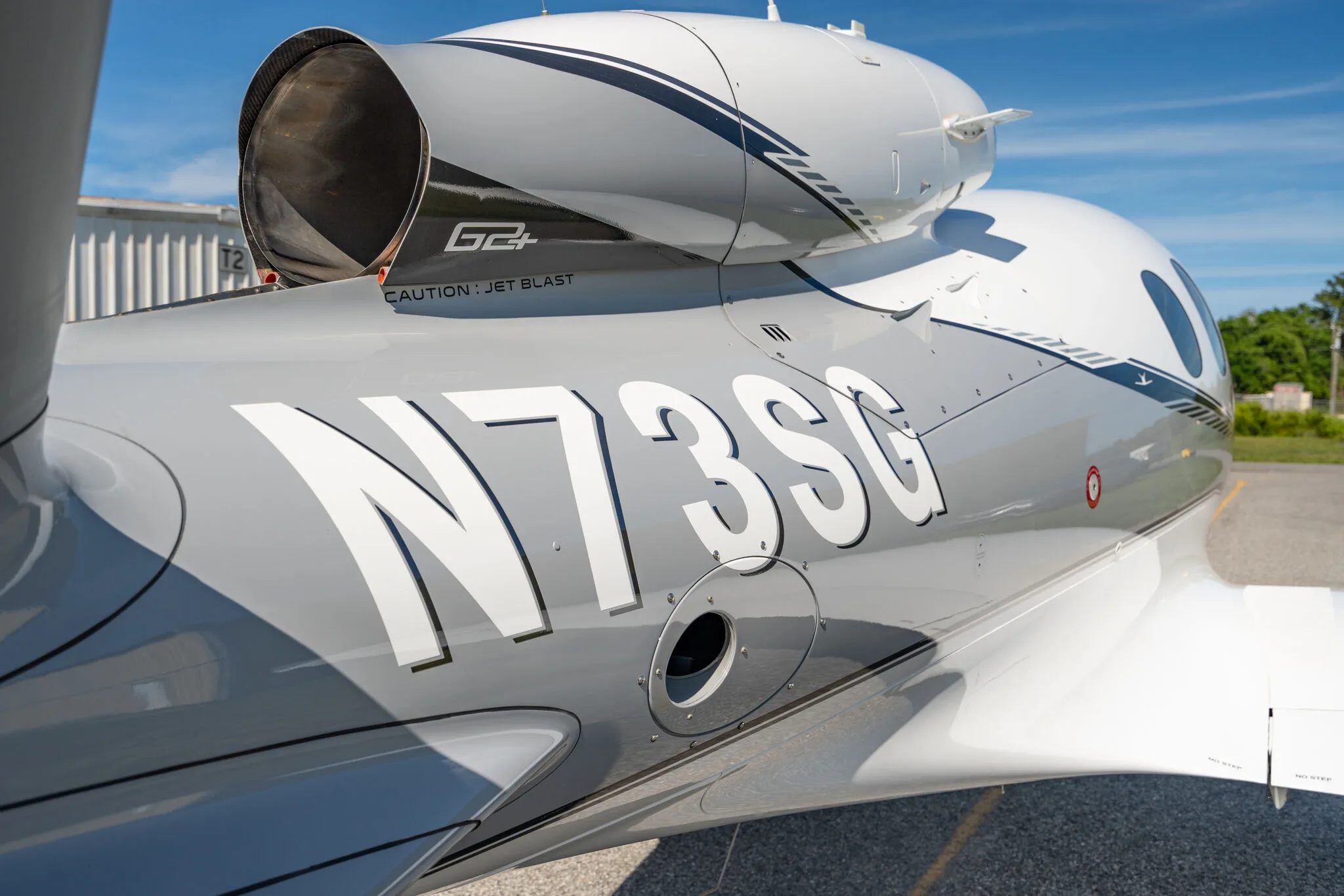 Close-up of the engine and N73SG tail number on the Cirrus Vision Jet, showing "G2+" and "CAUTION: JET BLAST" markings.