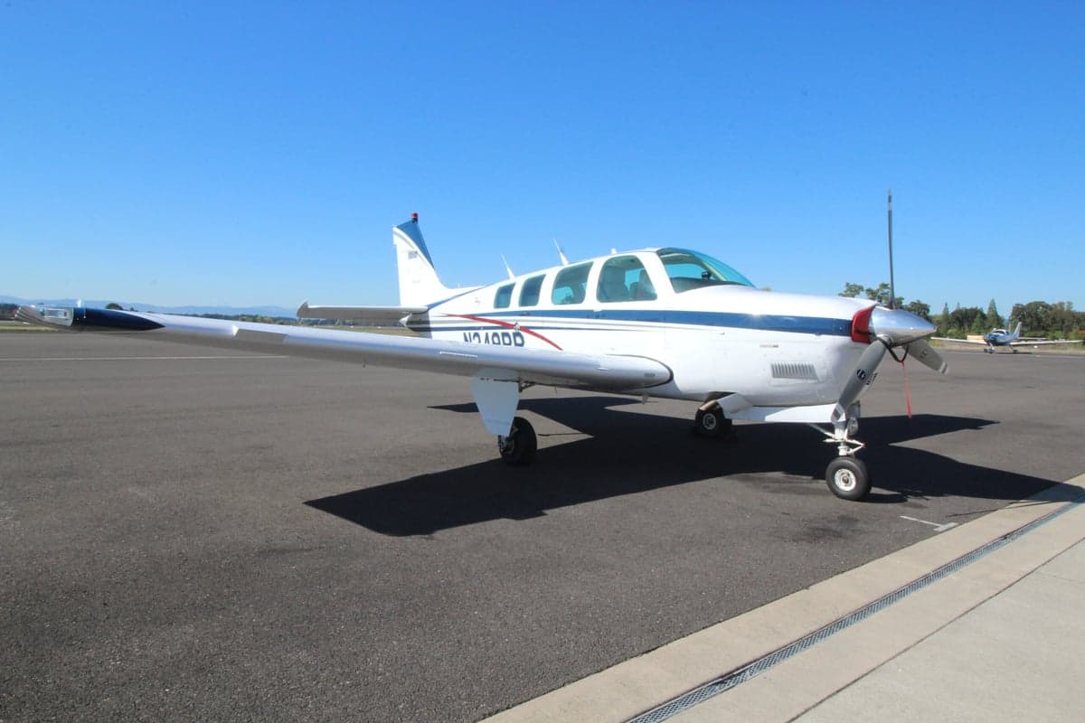 Front side view of a Beechcraft Bonanza aircraft with registration N240DD on the tarmac.