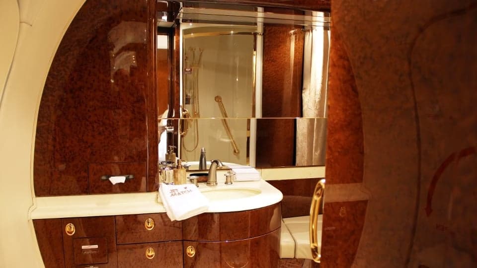A bathroom inside the aircraft cabin with a sink and mirror.