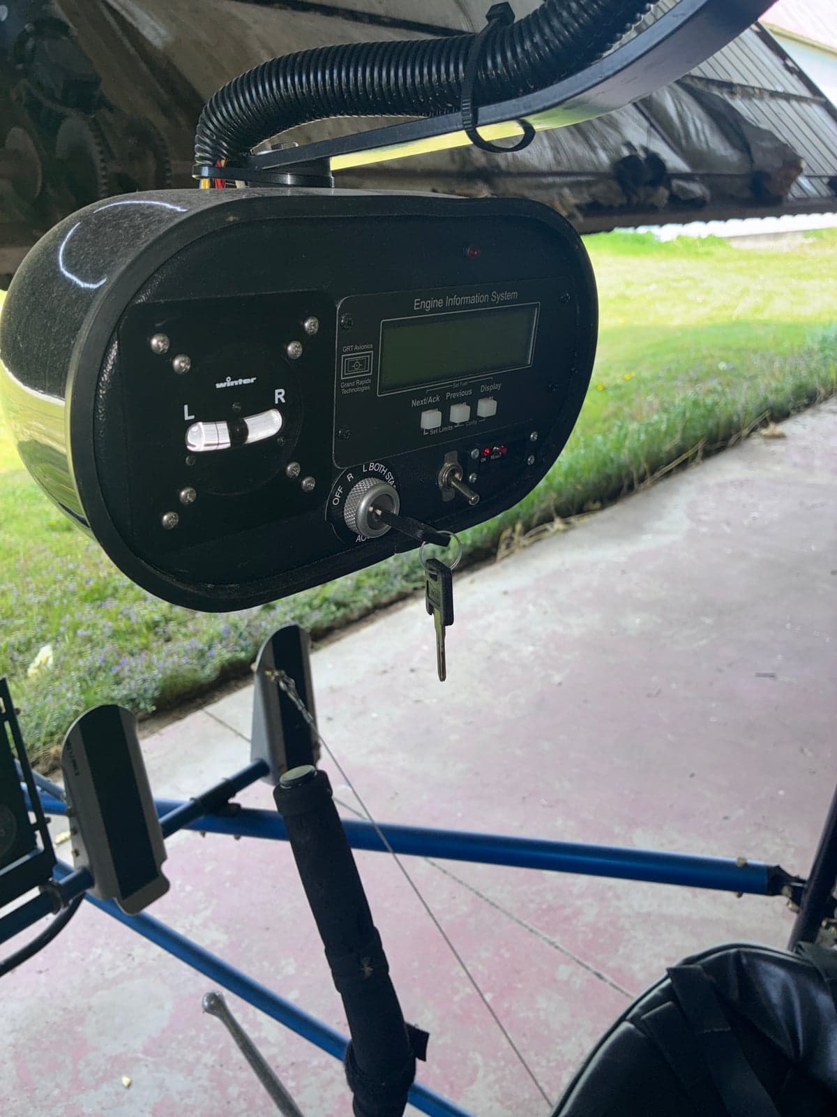 View of the engine information system display and ignition switch with keys, located in the cockpit area of the ultralight.