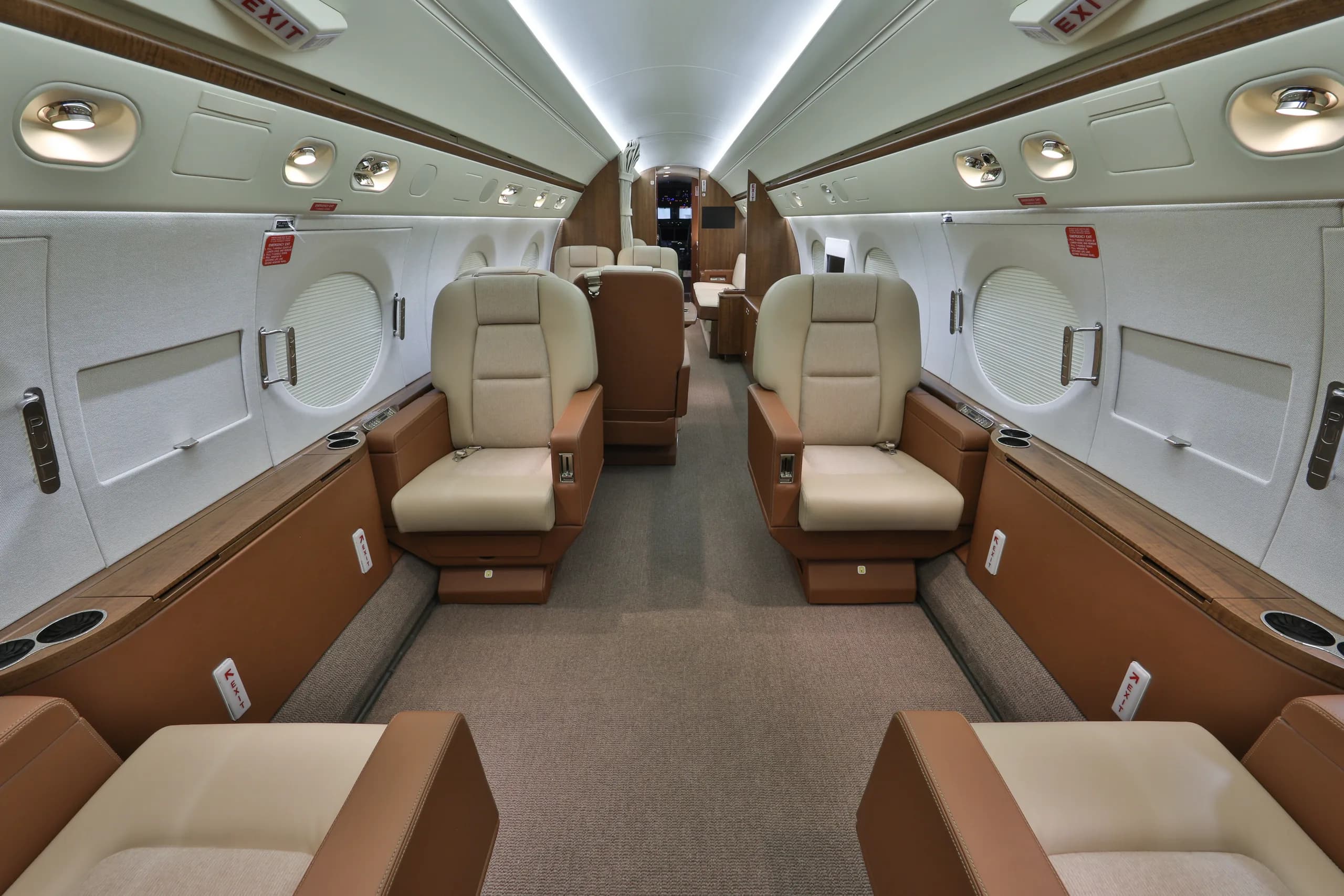 View of the aircraft's interior with tan leather seats and wood trim.