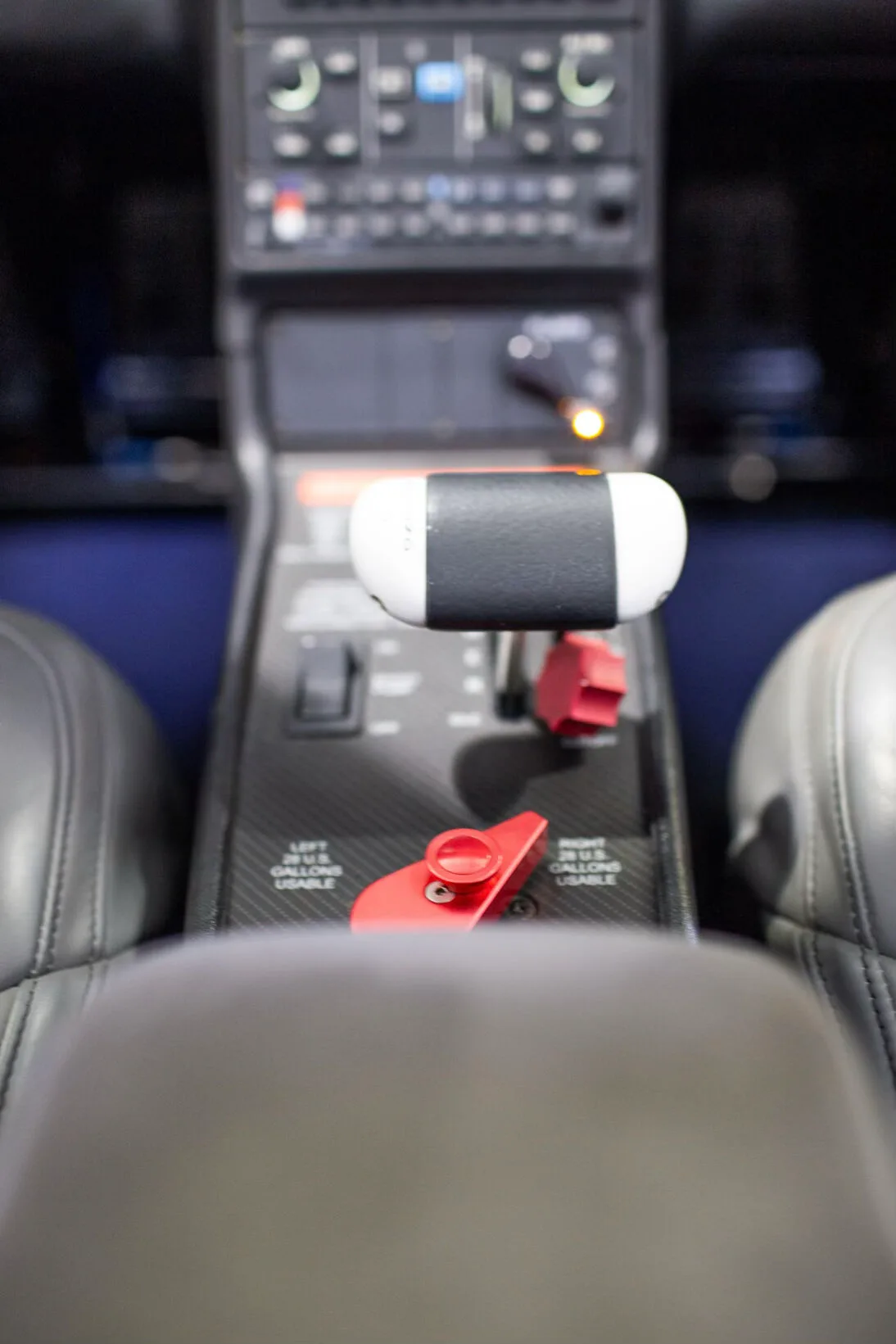 Close-up of the Cirrus SR20 throttle and red fuel selector levers.