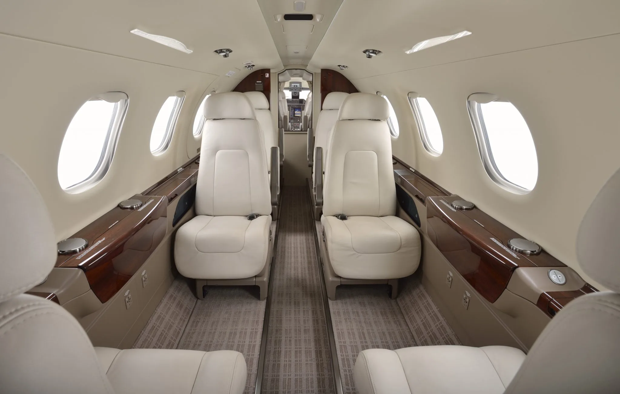 Aircraft cabin interior with white leather seats.