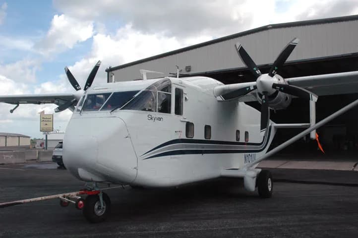 A Shorts Skyvan aircraft with tail number N101UV parked in front of a hangar.