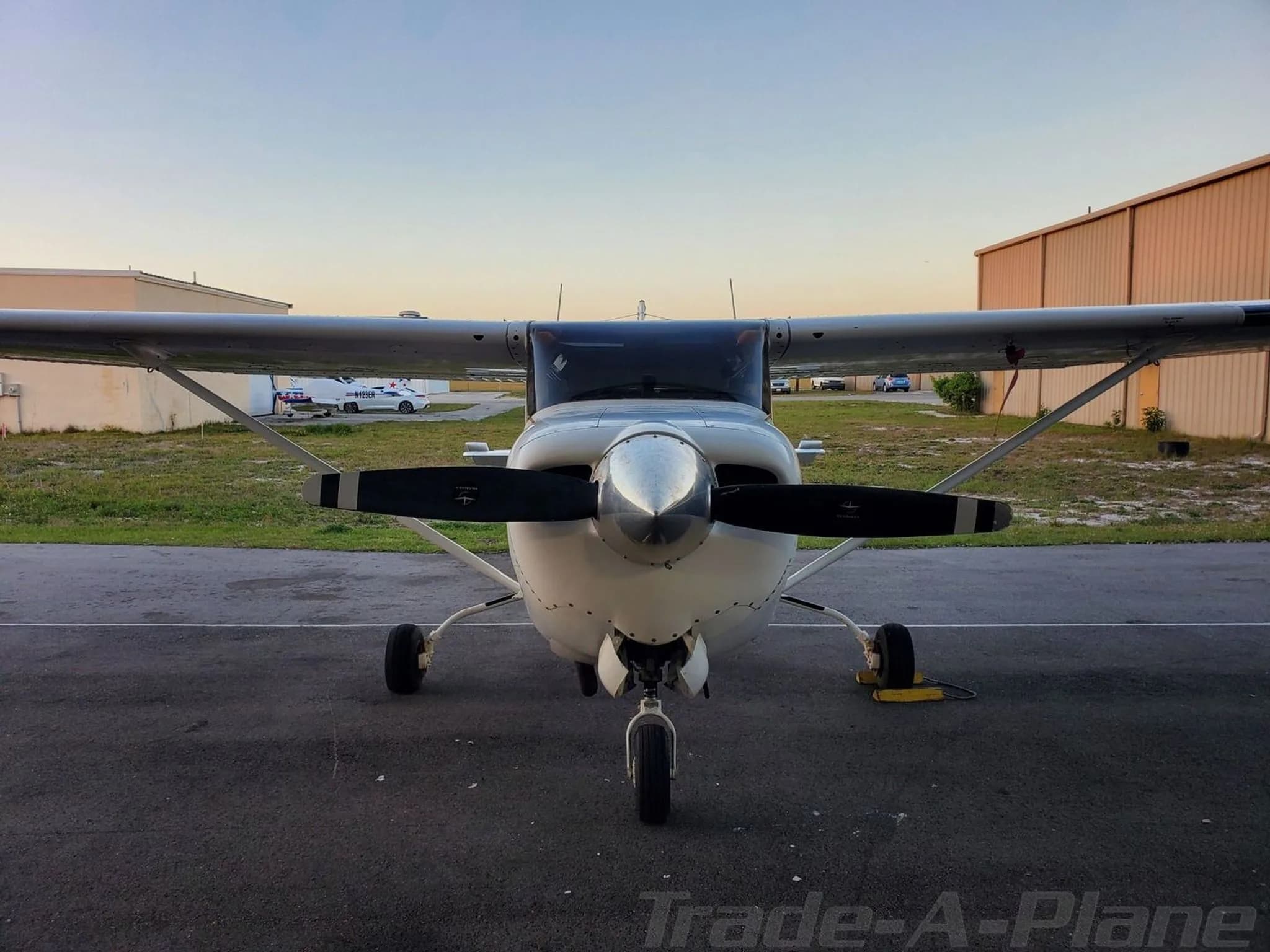 A head-on view of a white Cessna Cutlass RG II with a two-blade propeller on an airfield.