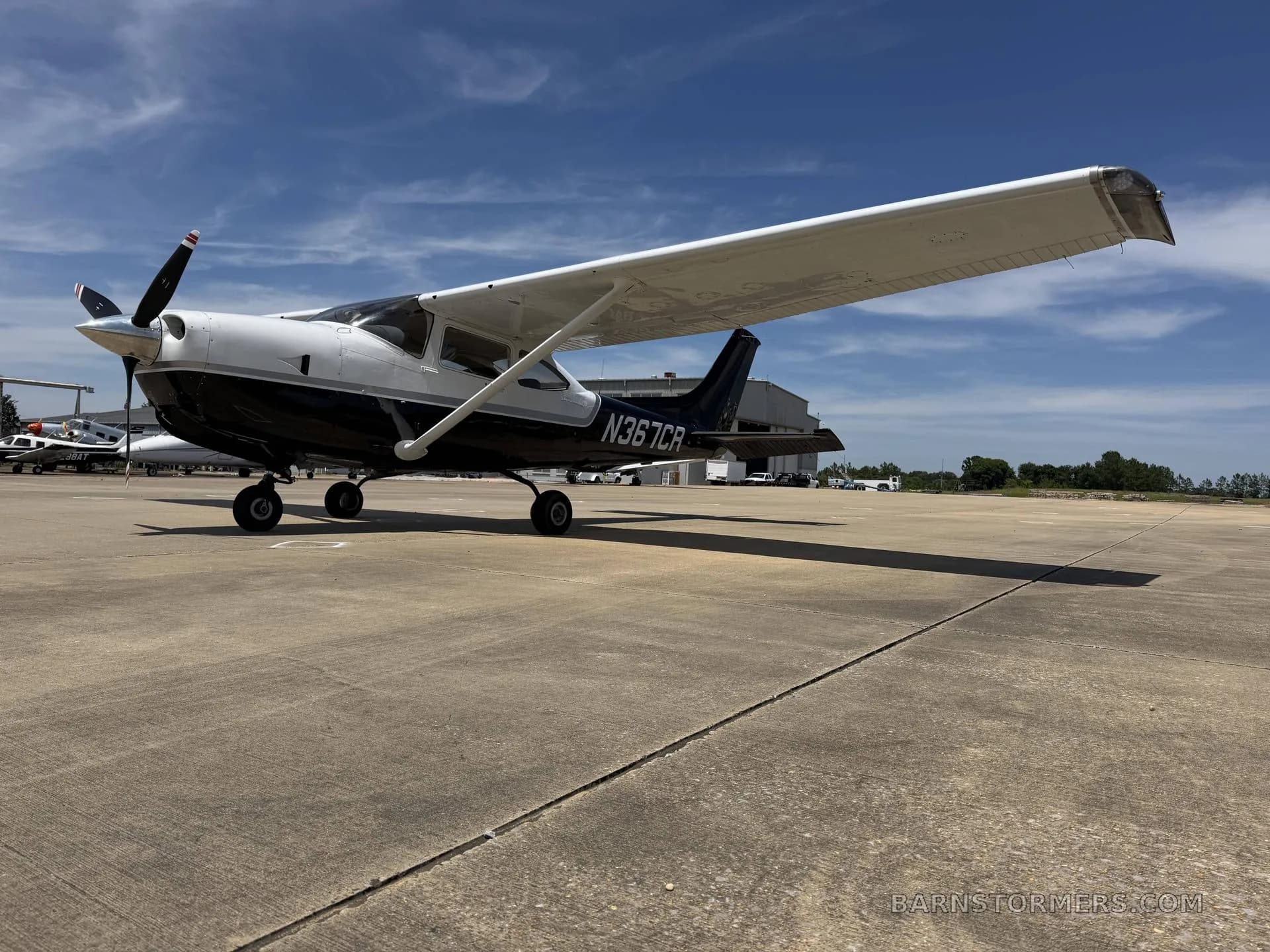 A black and white Cessna 182 Skylane (N367CR) parked on an asphalt ramp, viewed from the front-left.