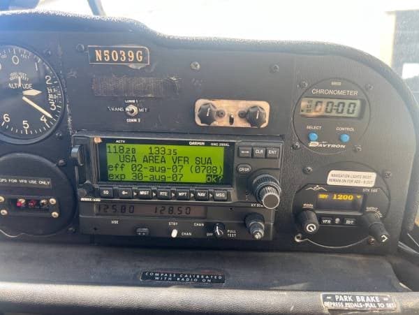 A close-up view of the aircraft's instrument panel, showing the radio stack, chronometer, and altimeter with registration N5039G.