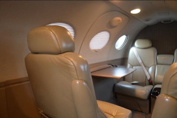 View of the Citation Mustang cabin with leather seats and a table.
