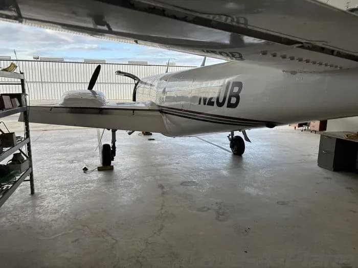 Side view of the N2UB aircraft parked inside a hangar.