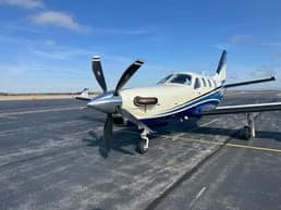 A TBM 930 aircraft with a blue and white paint scheme on the tarmac.