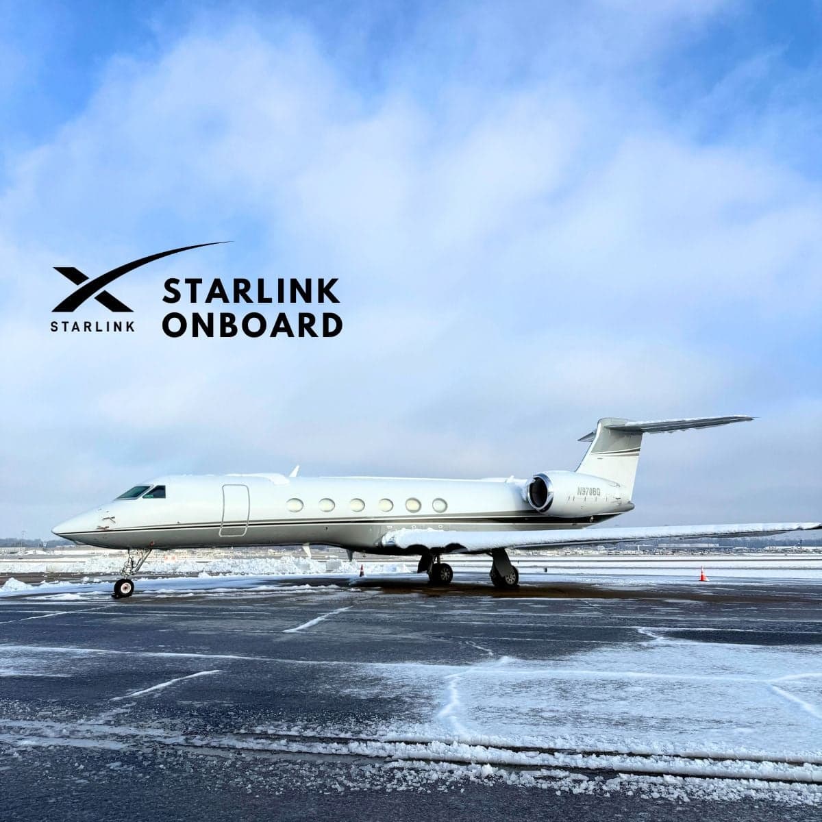 Side view of a white Gulfstream jet with Starlink logo on a snowy ramp.