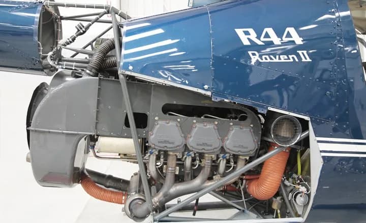 Close-up of the engine of a blue Robinson R44 Raven II helicopter.