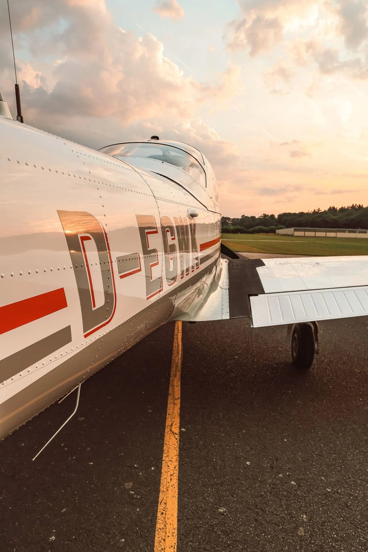 Close up of the side of the D-EGWK aircraft on the runway at sunset.