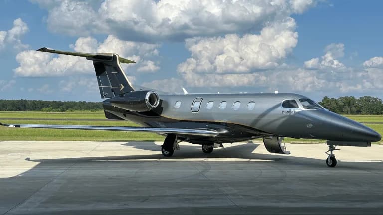 Side view of a Phenom 300 aircraft on the tarmac.