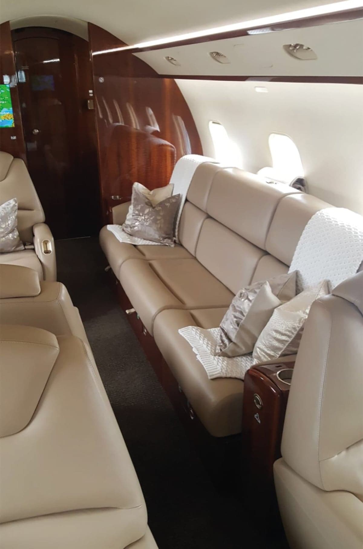 View of the aircraft interior with a tan couch and pillows.