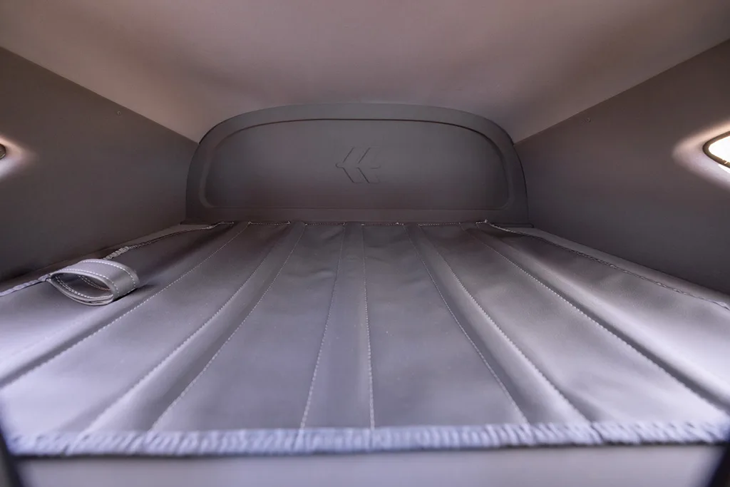 The grey upholstered rear cargo area of an aircraft cabin.
