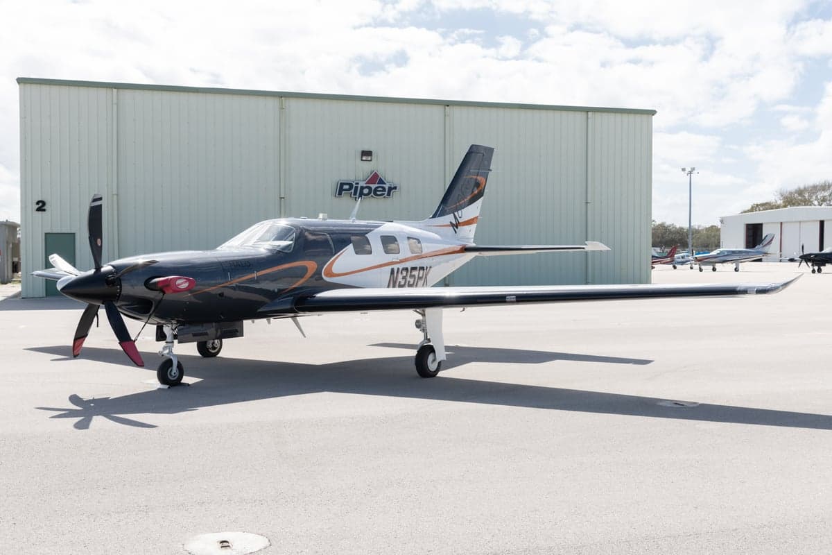 A Piper M600 HALO, registration N35PK, is parked on the tarmac in front of a Piper building.