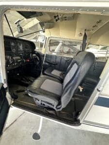 View of the front seats and cockpit of the aircraft from the open door.