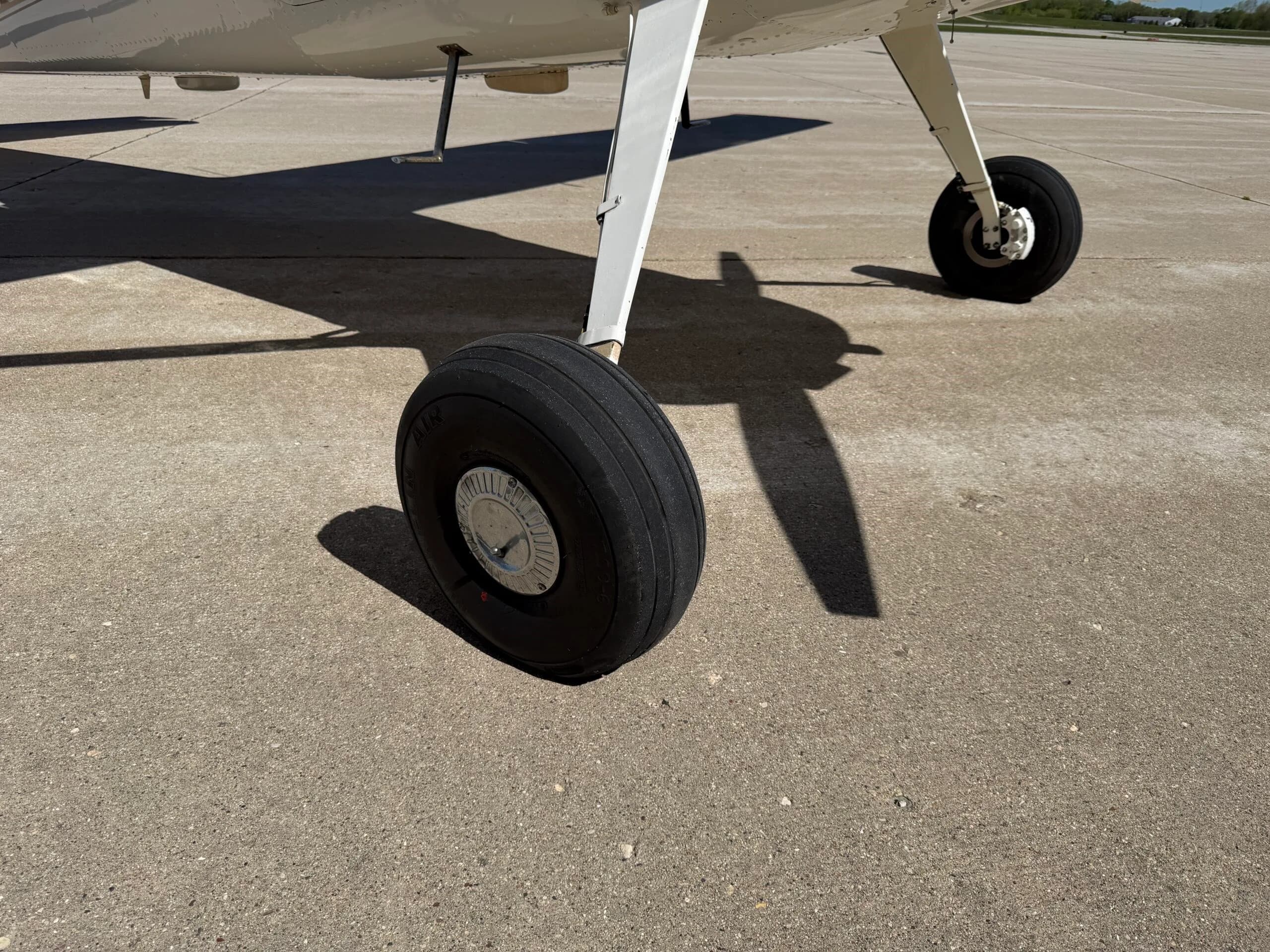 Close-up of the right main landing gear wheel of a Cessna 172 on concrete.