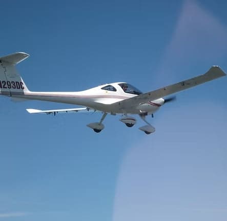 Diamond DA40 aircraft in flight against a blue sky.
