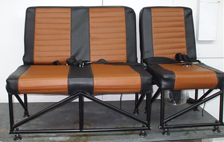 Two brown and black aircraft seats with metal frames.