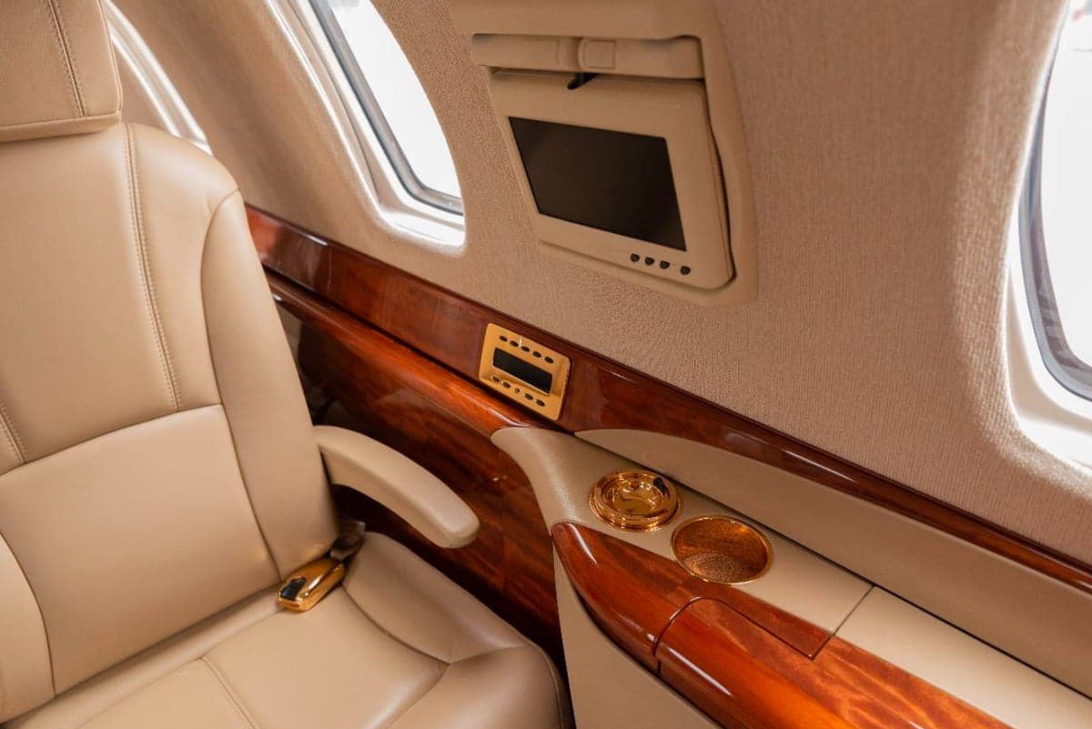 Close-up of a leather seat and wood trim in the aircraft cabin.
